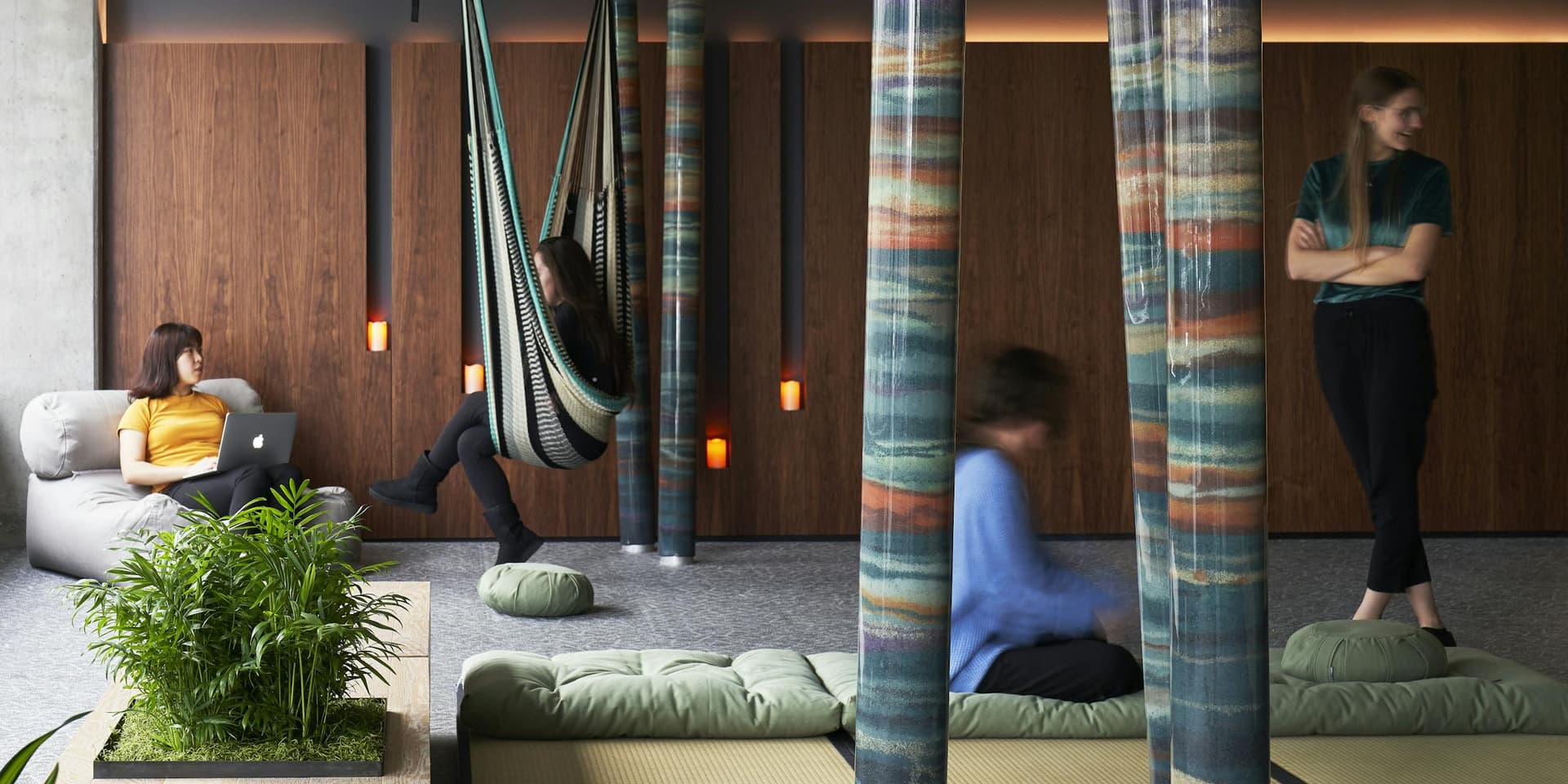 Wellness lounge with hanging hammock chair and meditation cushions