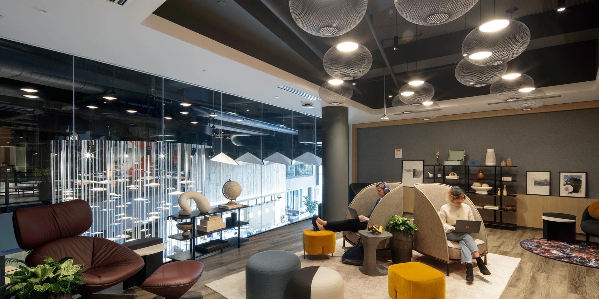 Modern office lounge with mesh pendant lights and cozy seating