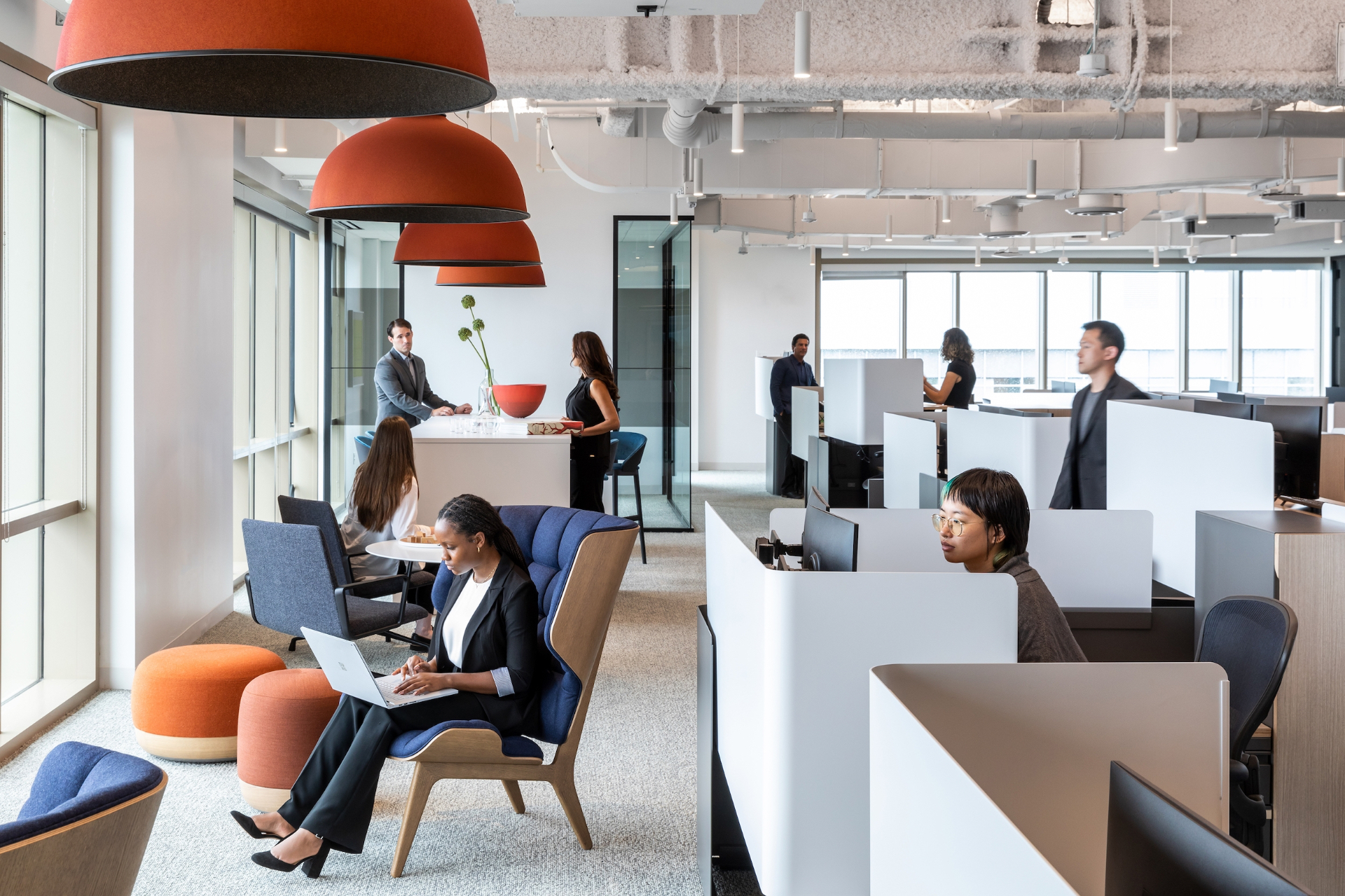 Open office with red pendant lamps and mix of focus pods and lounge seating
